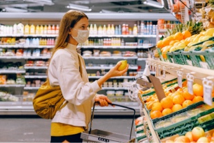 スーパーで女性が果物を選んでいる
