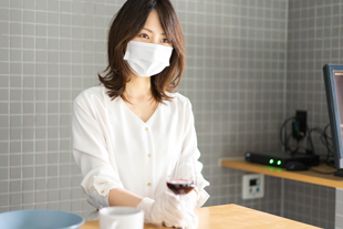 キッチンでマスクをした女性が料理をしている