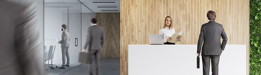おしゃれなオフィスの入り口で女性と男性が会話している横長の画像